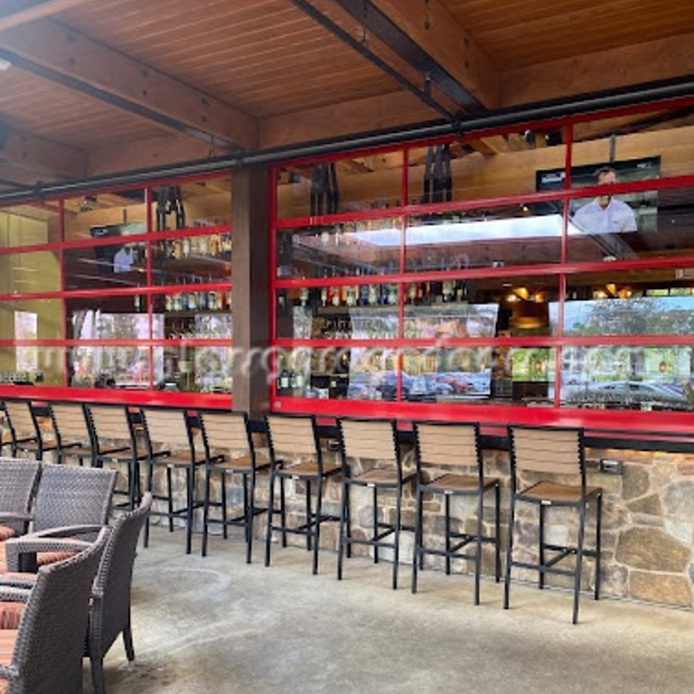 Restaurant patio featuring a red framed bp Glasss Garage Door as a the bar counter shutter.