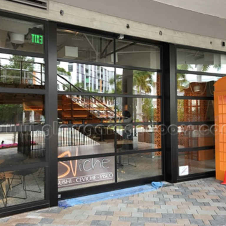 Street view of Doral restaurant with a bp Glass Garage Door blending indoor and outdoor areas