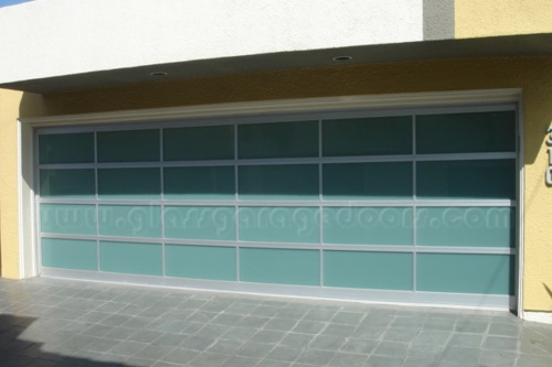Modern residential garage with a wide full-view obscured bp glass garage door and light gray framing.