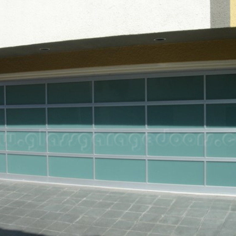 Modern residential garage with a wide full-view obscured bp glass garage door and light gray framing.