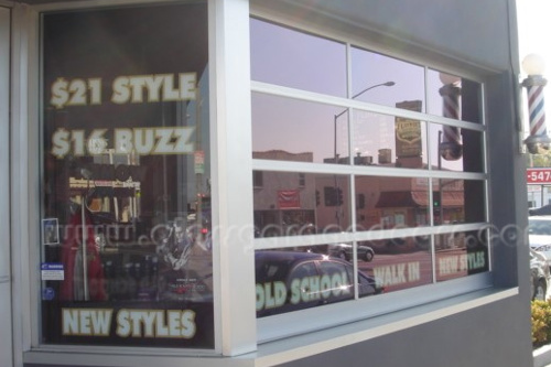 Modern commercial bp glass storefront, serving as an expansive window display for a barbershop.